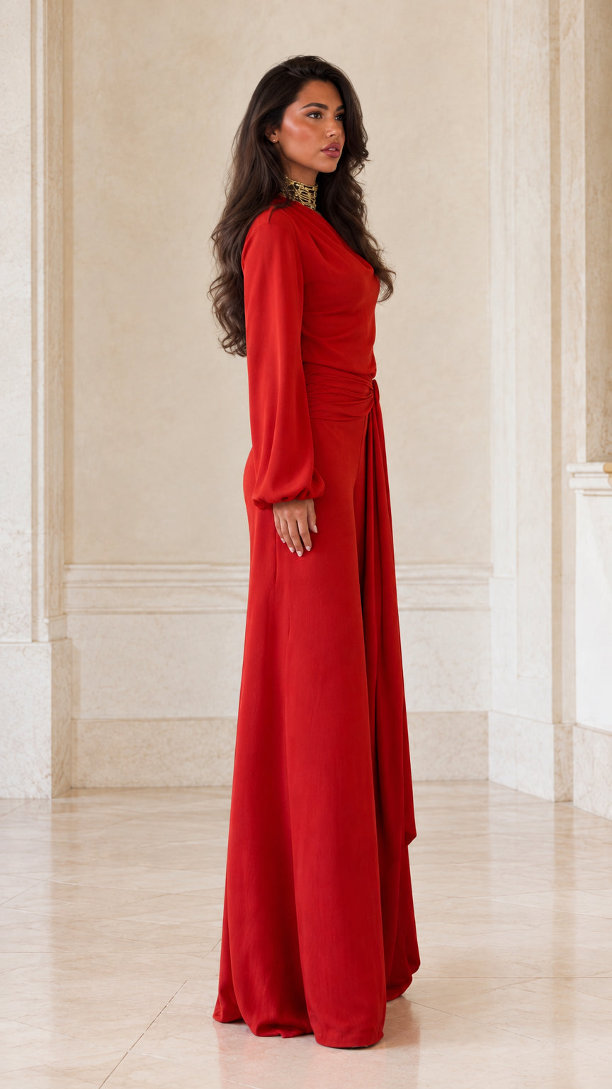 Side profile view of woman modeling red asymmetric wide-leg evening jumpsuit