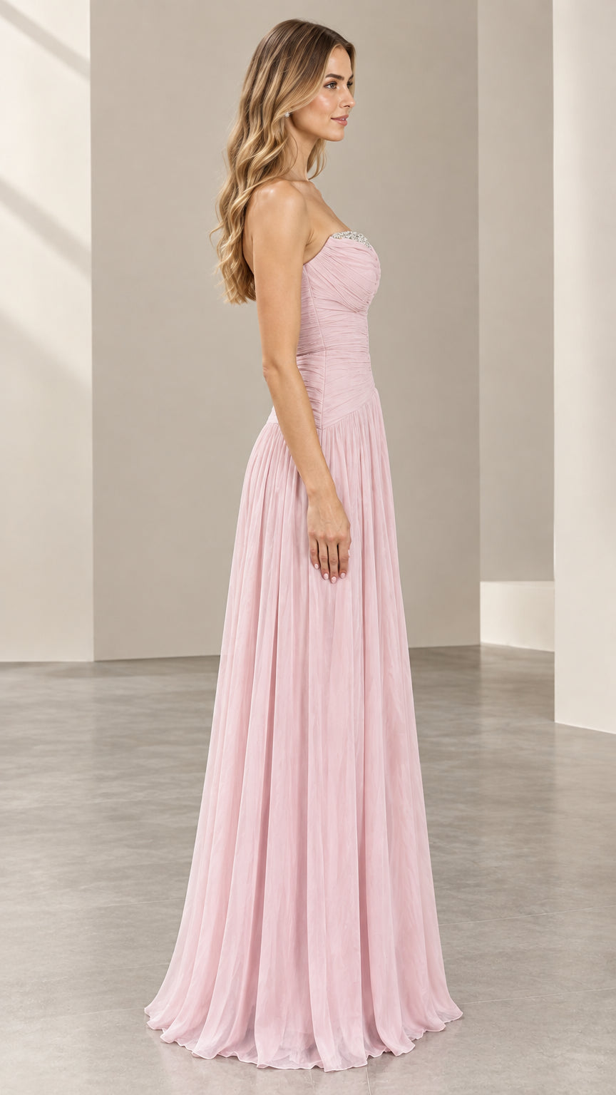 Side view of woman wearing the blush pink strapless maxi formal dress