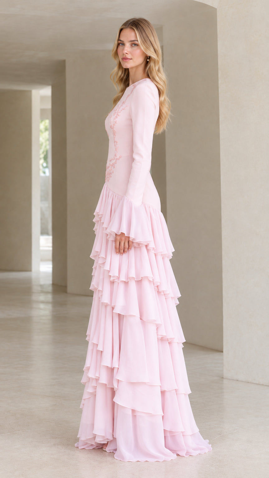 Side profile of woman wearing blush pink tiered ruffle long sleeve evening dress