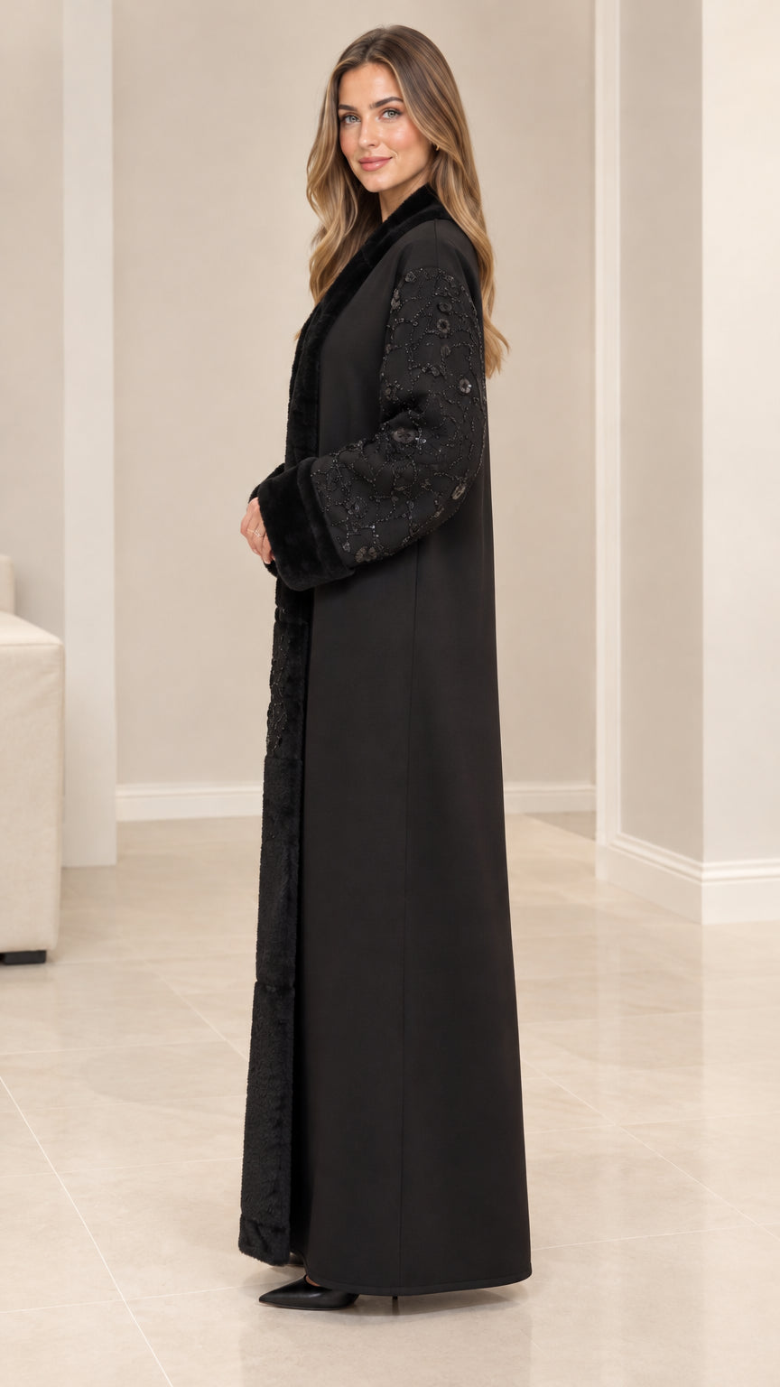 Side profile view of elegant black long coat with plush fur trim and embellished sleeves