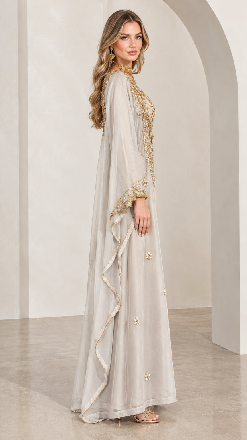 Side profile view of woman wearing flowing silver grey beaded kaftan dress