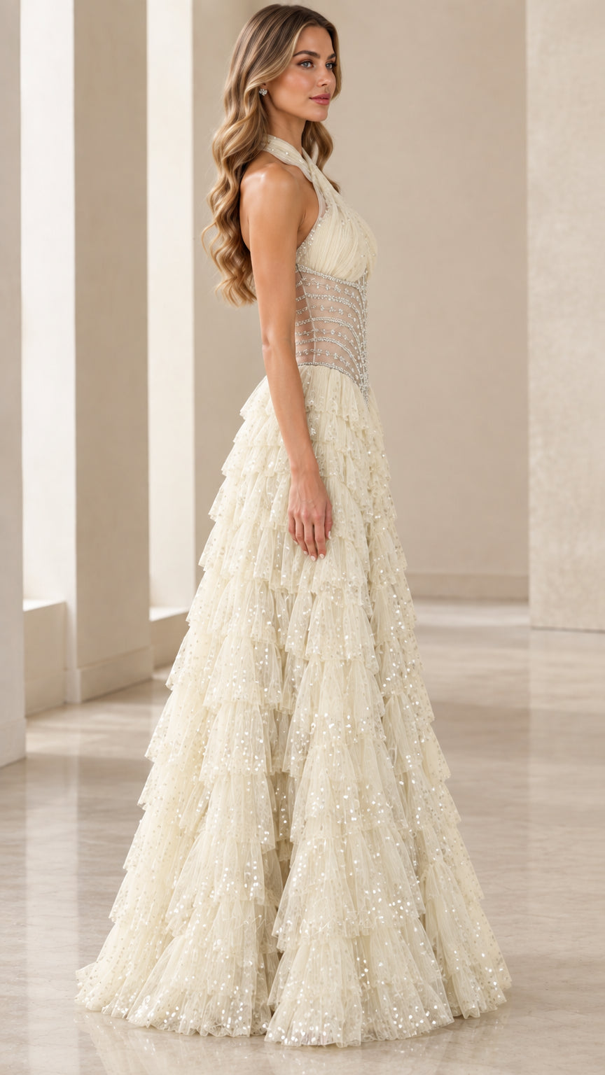 Model wearing an Ivory halter neck tiered tulle evening dress side profile view