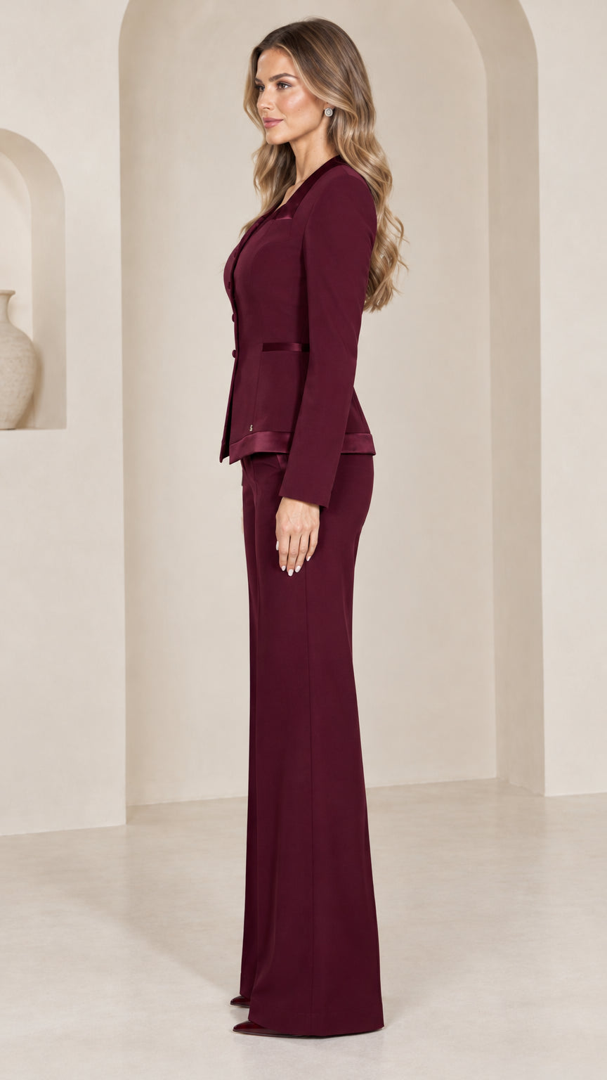 Side profile view of burgundy tailored two-piece pant suit