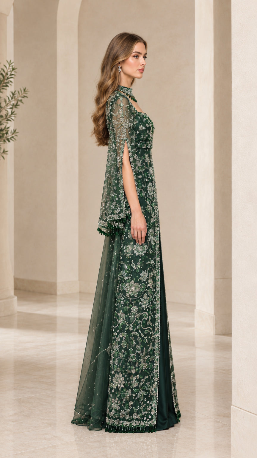 Side profile view of emerald green embroidered gown showing split cape sleeve detailing