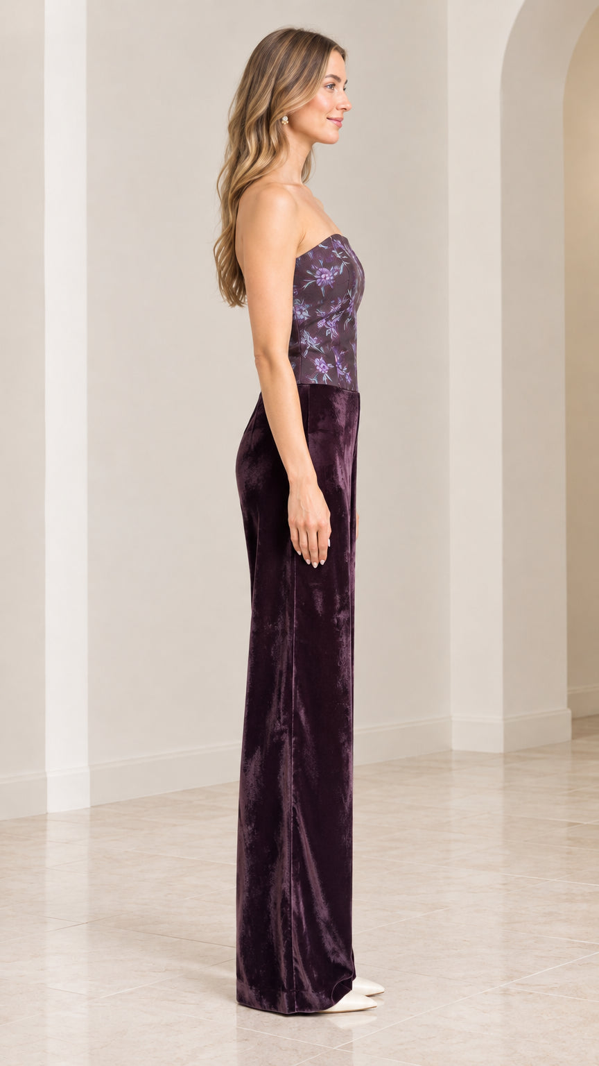 Side profile of woman in strapless plum purple velvet jumpsuit