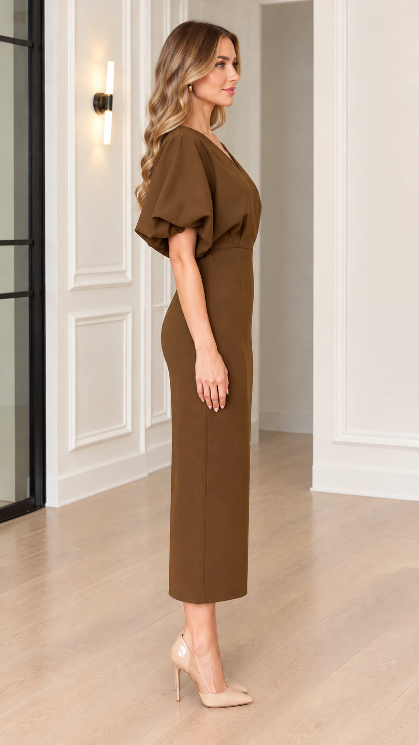 Side profile view of woman wearing brown puff sleeve midi dress with pointed heels