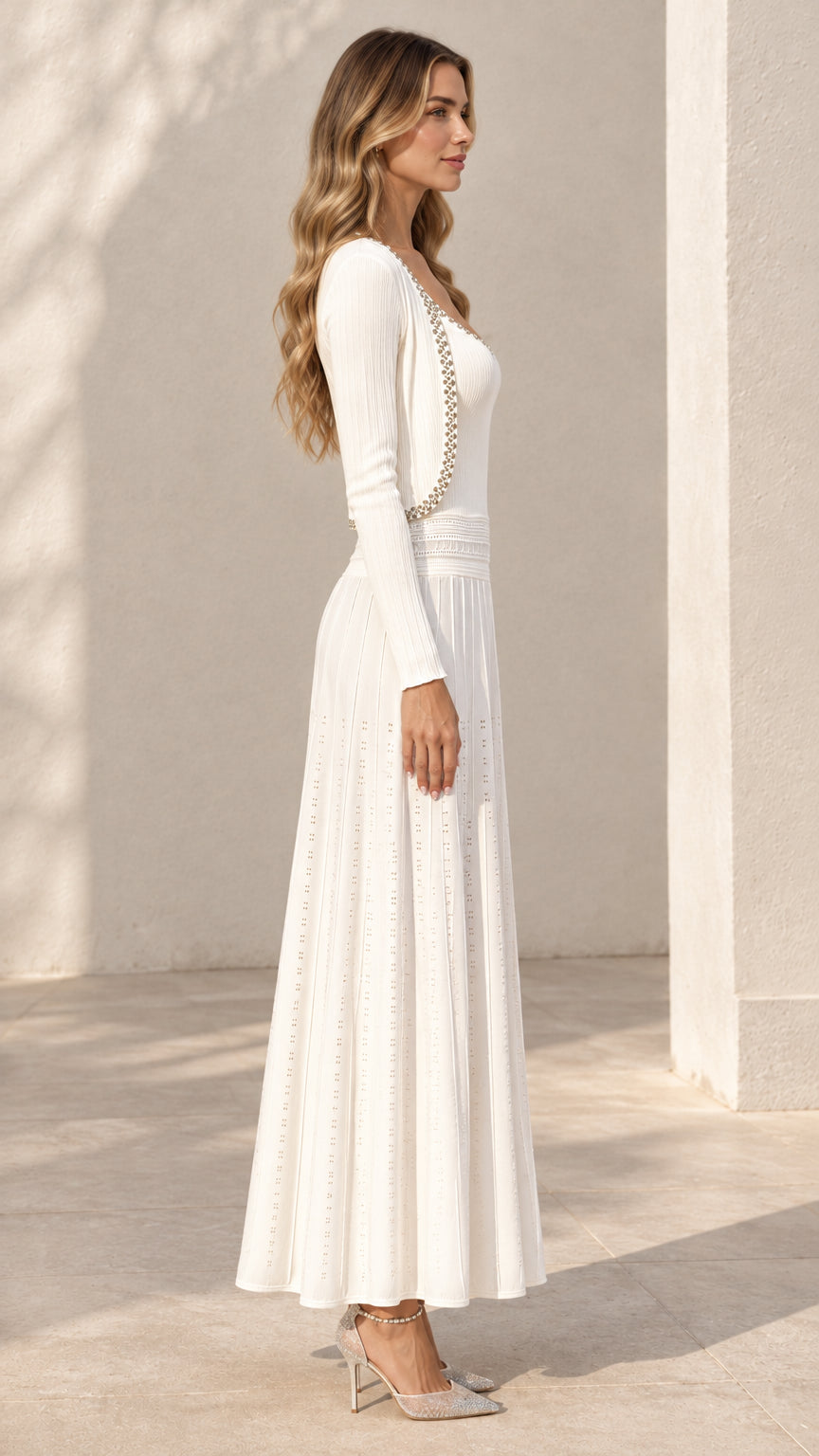 Side profile view of ivory white pleated knit maxi dress and matching cardigan