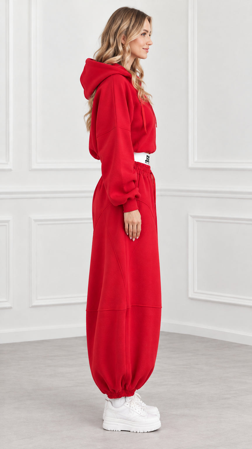 Side profile of model wearing red cropped tracksuit set