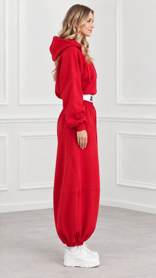 Side profile of model wearing red cropped tracksuit set