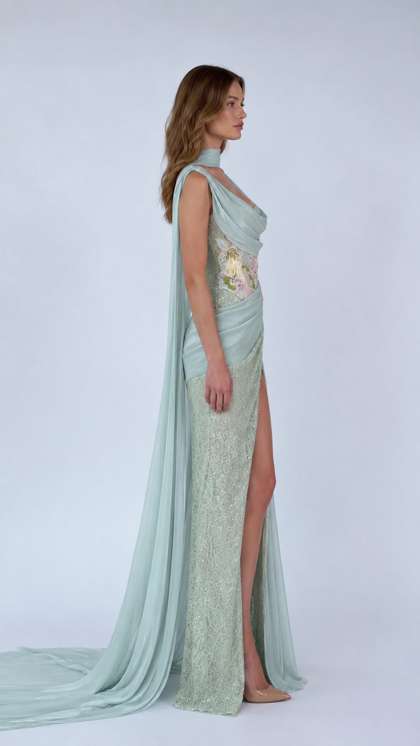 Side profile view of Sage Green evening gown highlighting high slit and chiffon cape