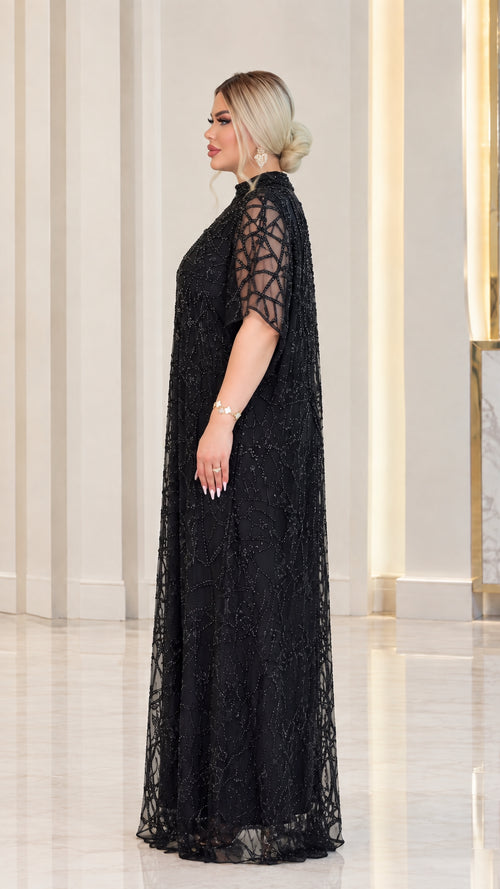 Side profile of black sequin embellished mesh formal maxi gown