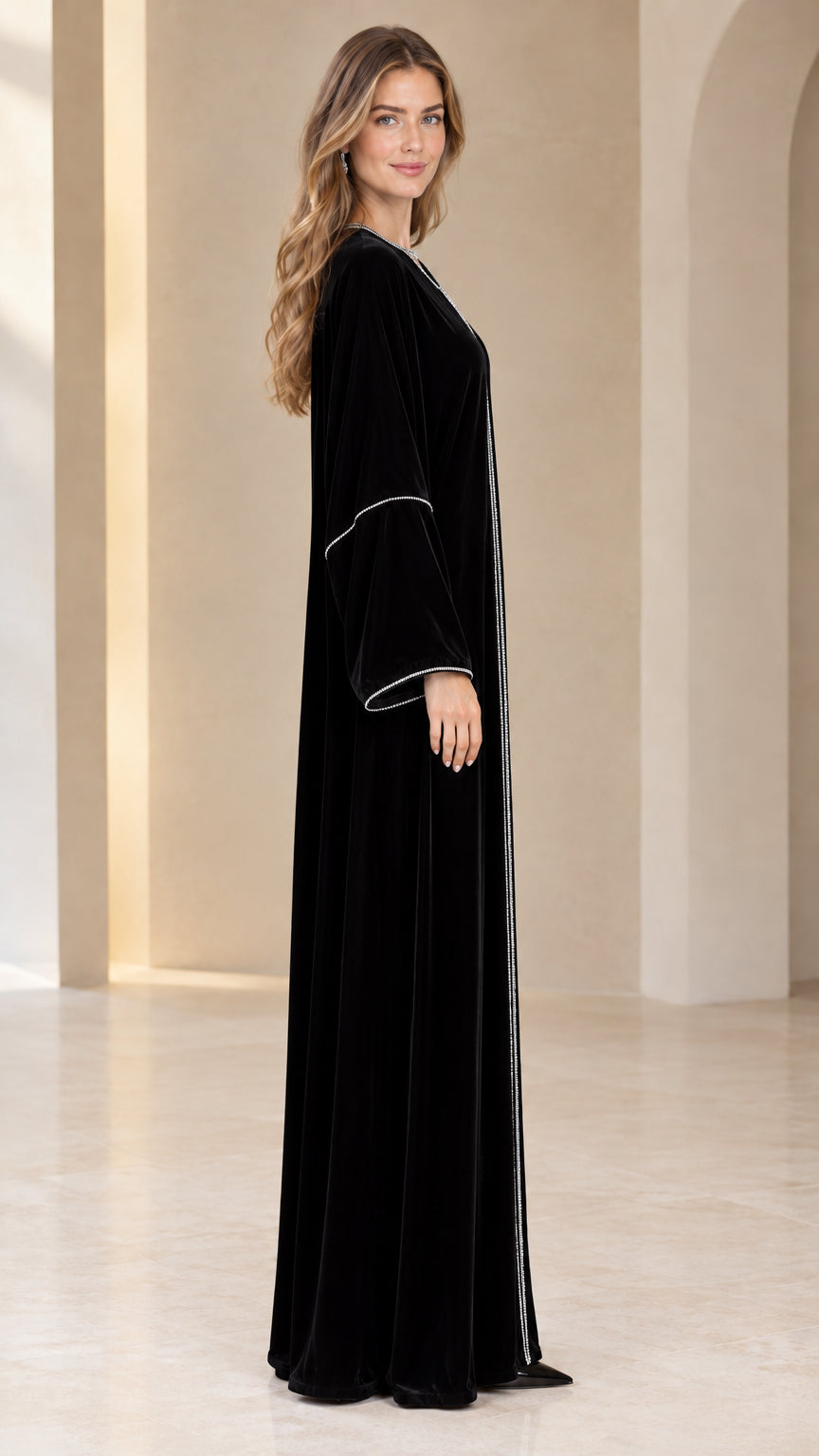 Side profile view of elegant black velvet long-sleeve maxi dress
