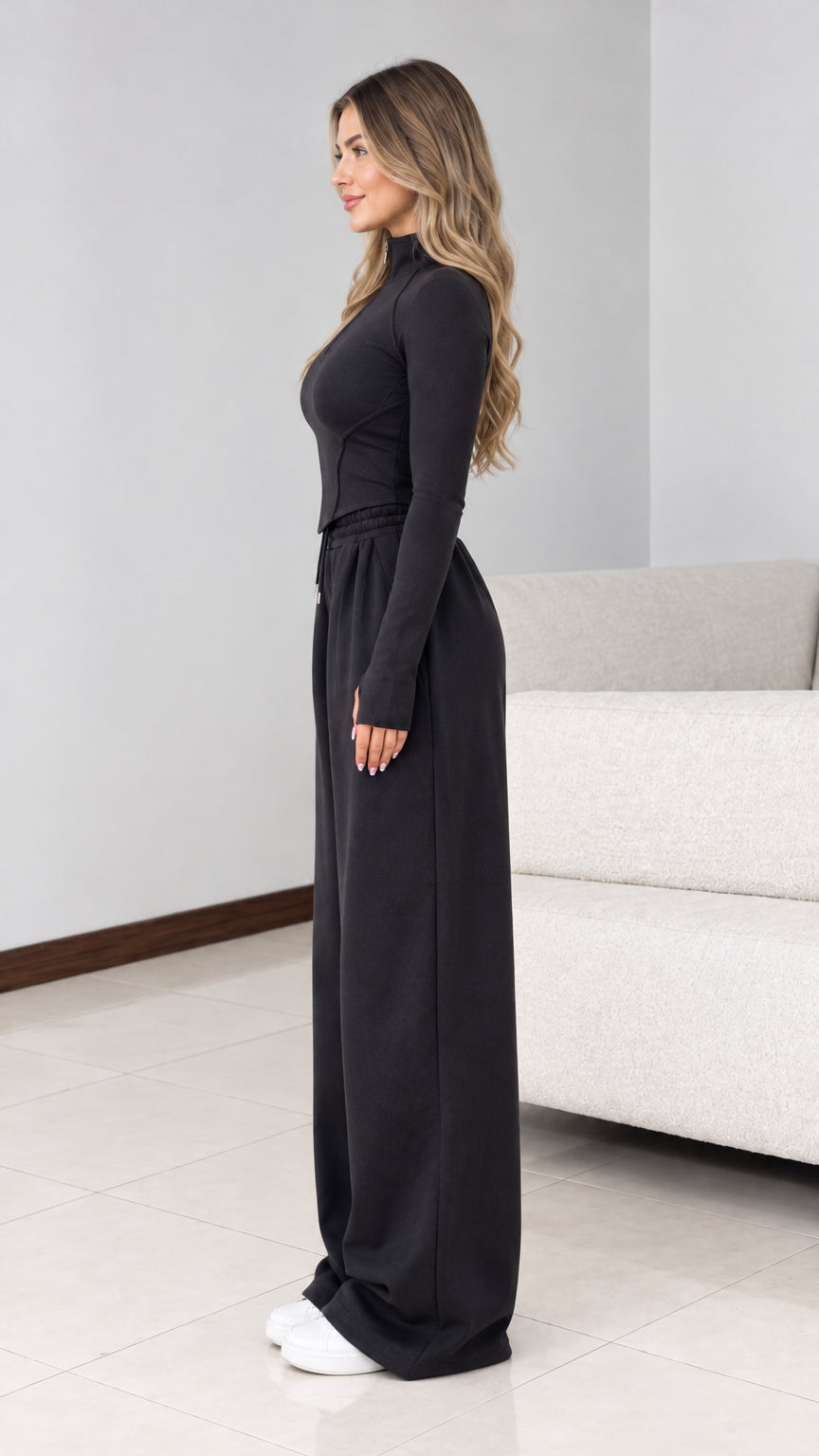 Side view of model wearing black two-piece wide leg tracksuit