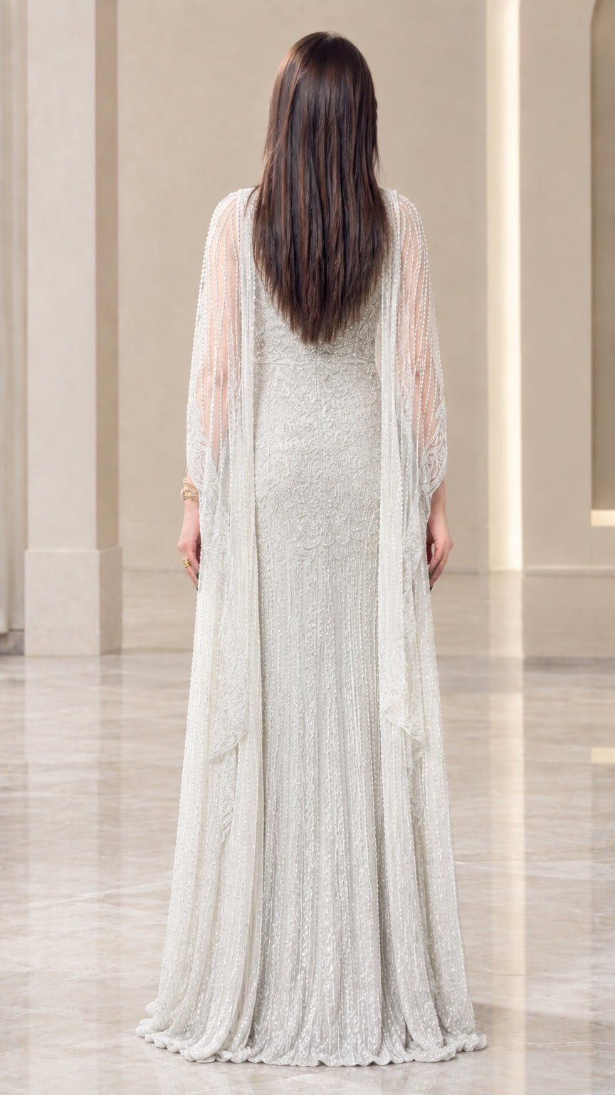 Back view of silver sequin embellished cape gown showing sweeping hem
