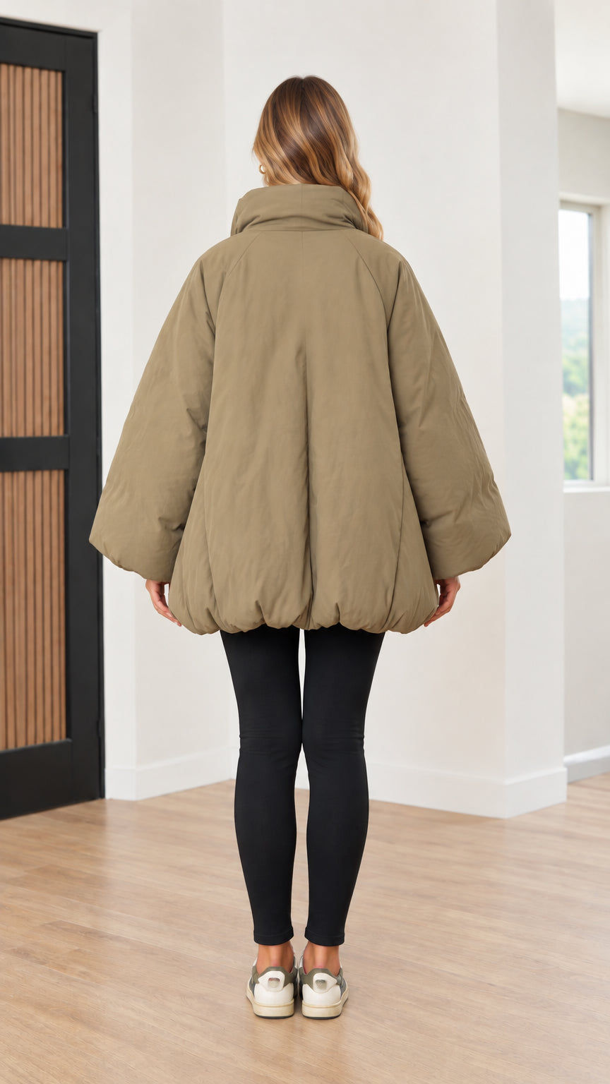 Back view of woman showing rounded cocoon silhouette of olive green puffer jacket