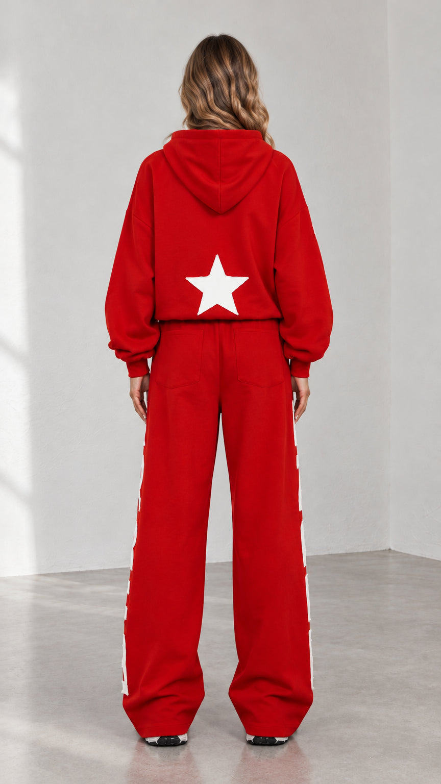 Back view of woman wearing red hoodie and sweatpants featuring back star print