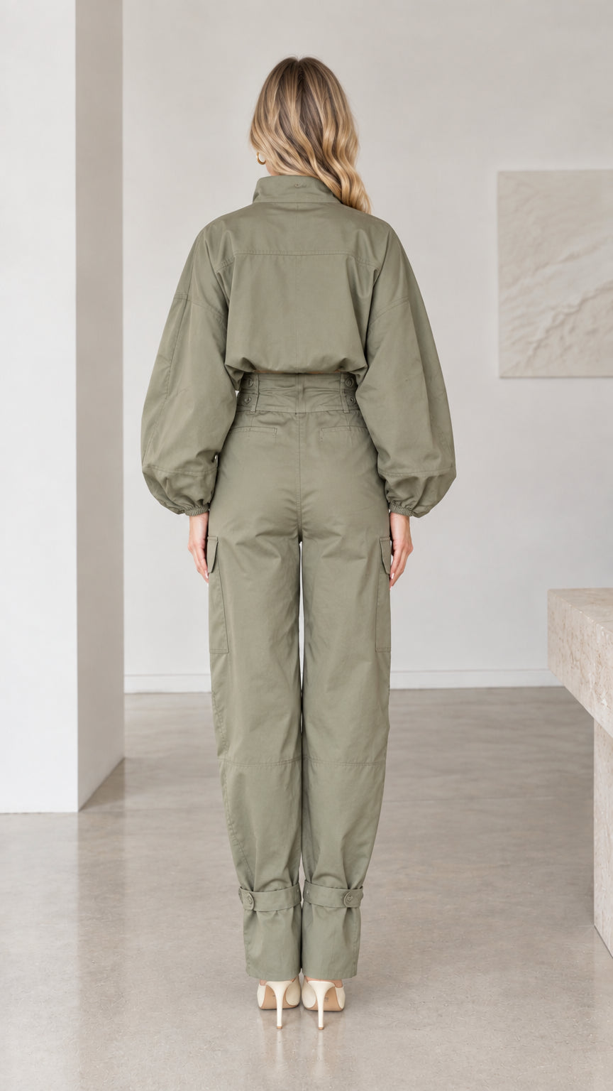 Back full-length view of olive green button-up cargo jumpsuit with tapered legs