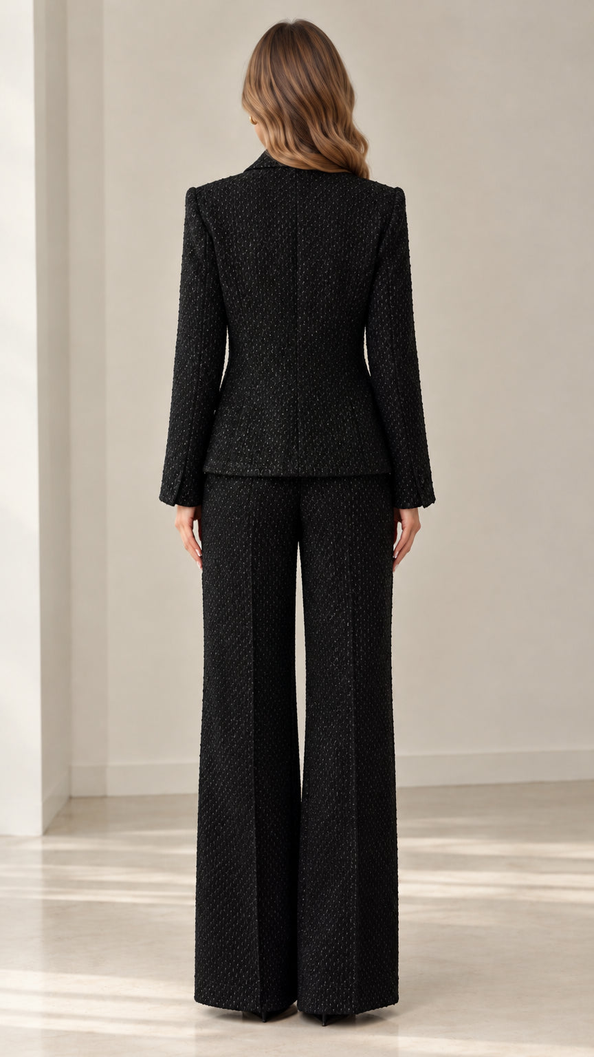 Back view of woman wearing tailored black tweed blazer and wide leg pants