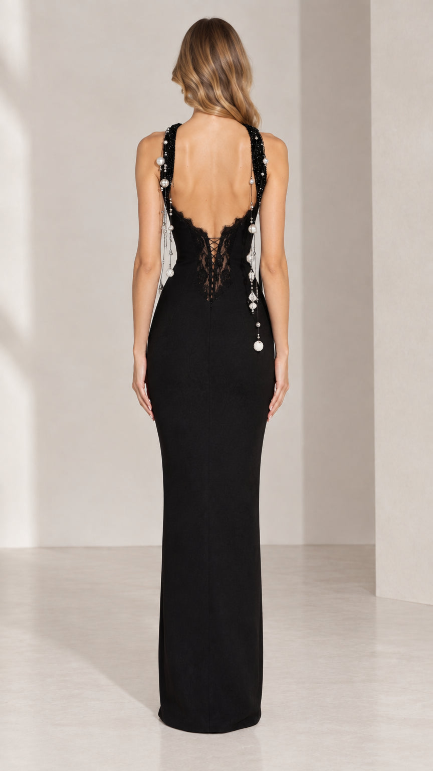 Back view of black formal dress featuring open back with lace trim and beaded strands