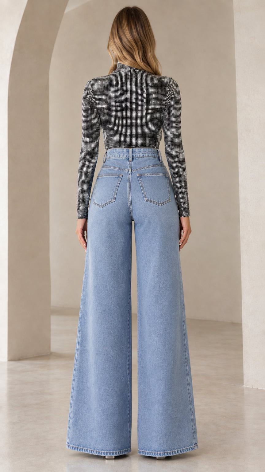 Back view of model in high-rise wide-leg jeans and long sleeve sparkle top
