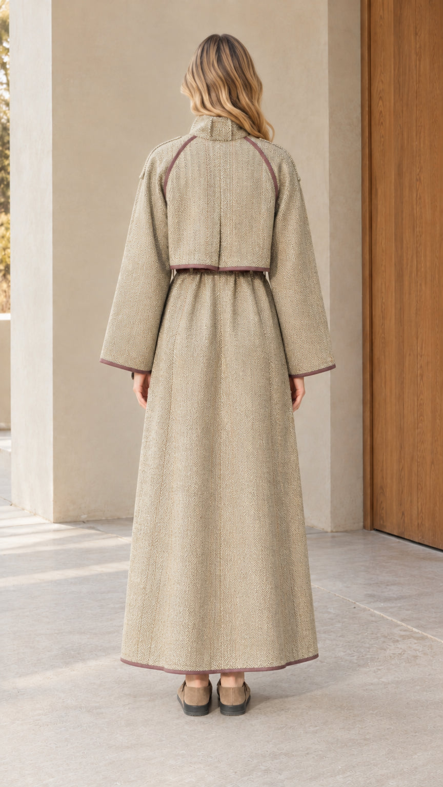 Back view of woman wearing full length sage green tweed coat with back flap detail