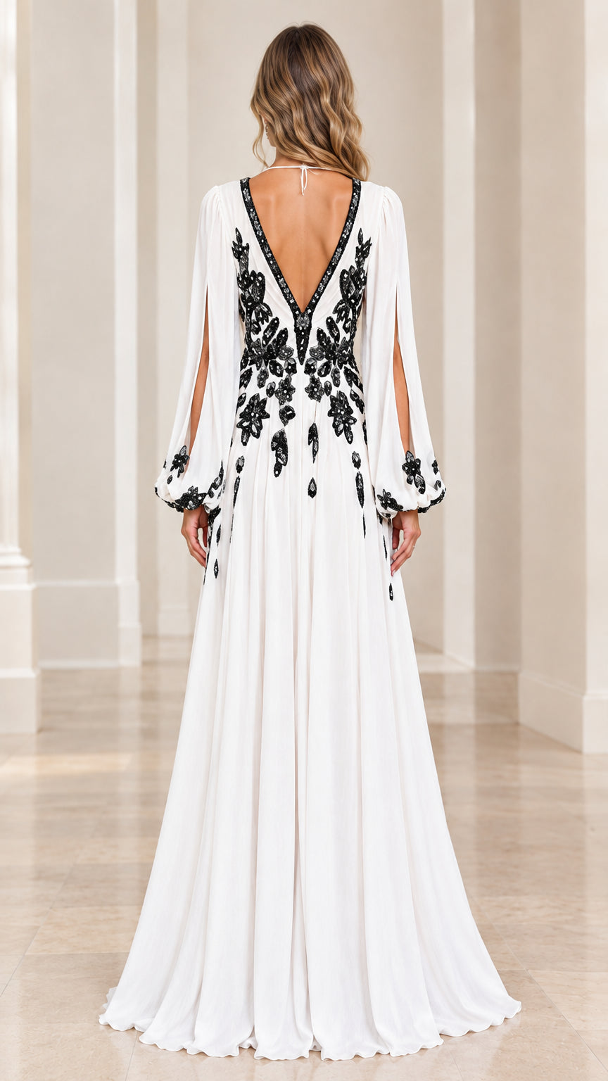 Back view of model showing open V-back and flowing white chiffon gown