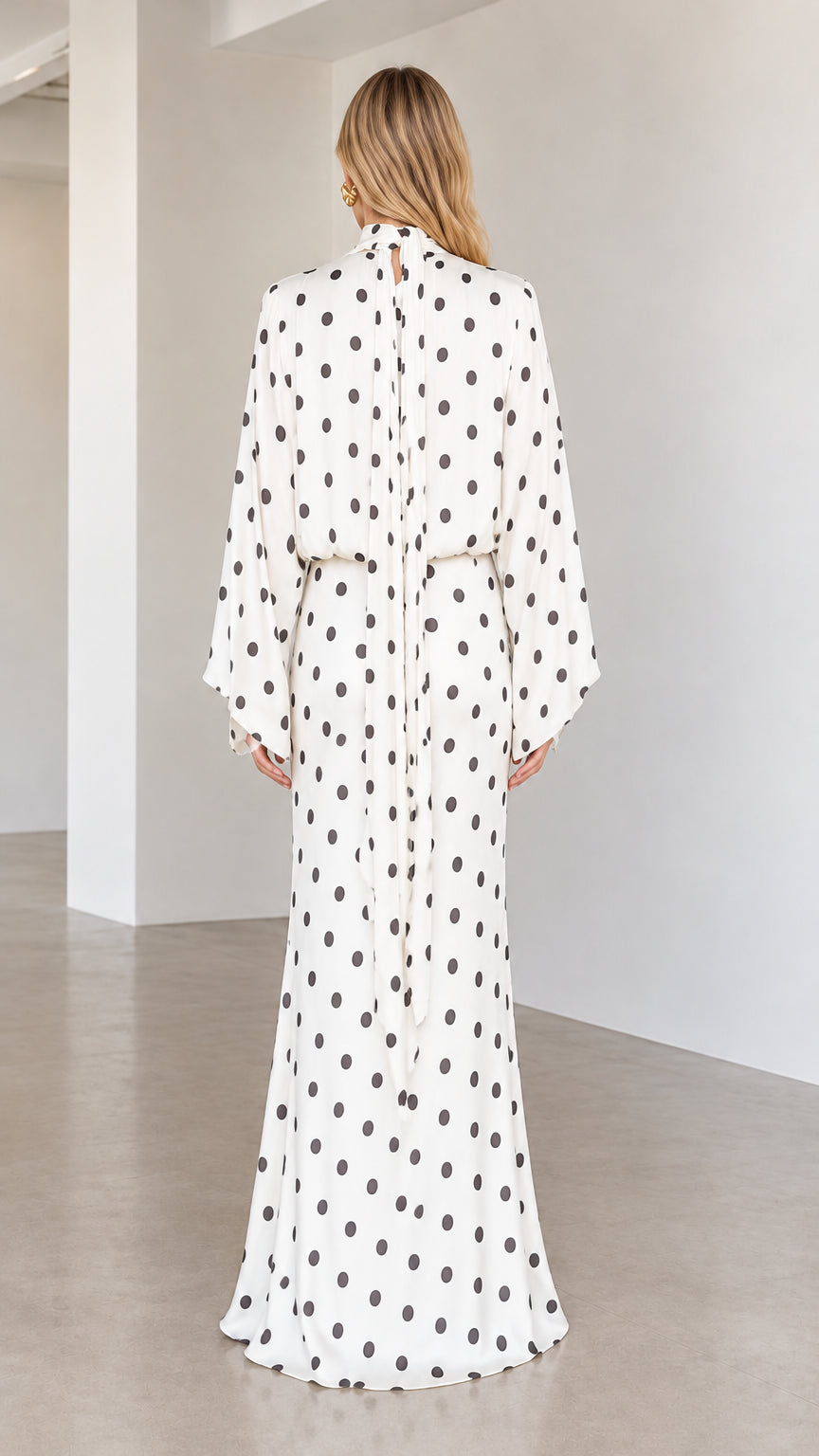 Back view of white high neck polka dot maxi dress showing back drape