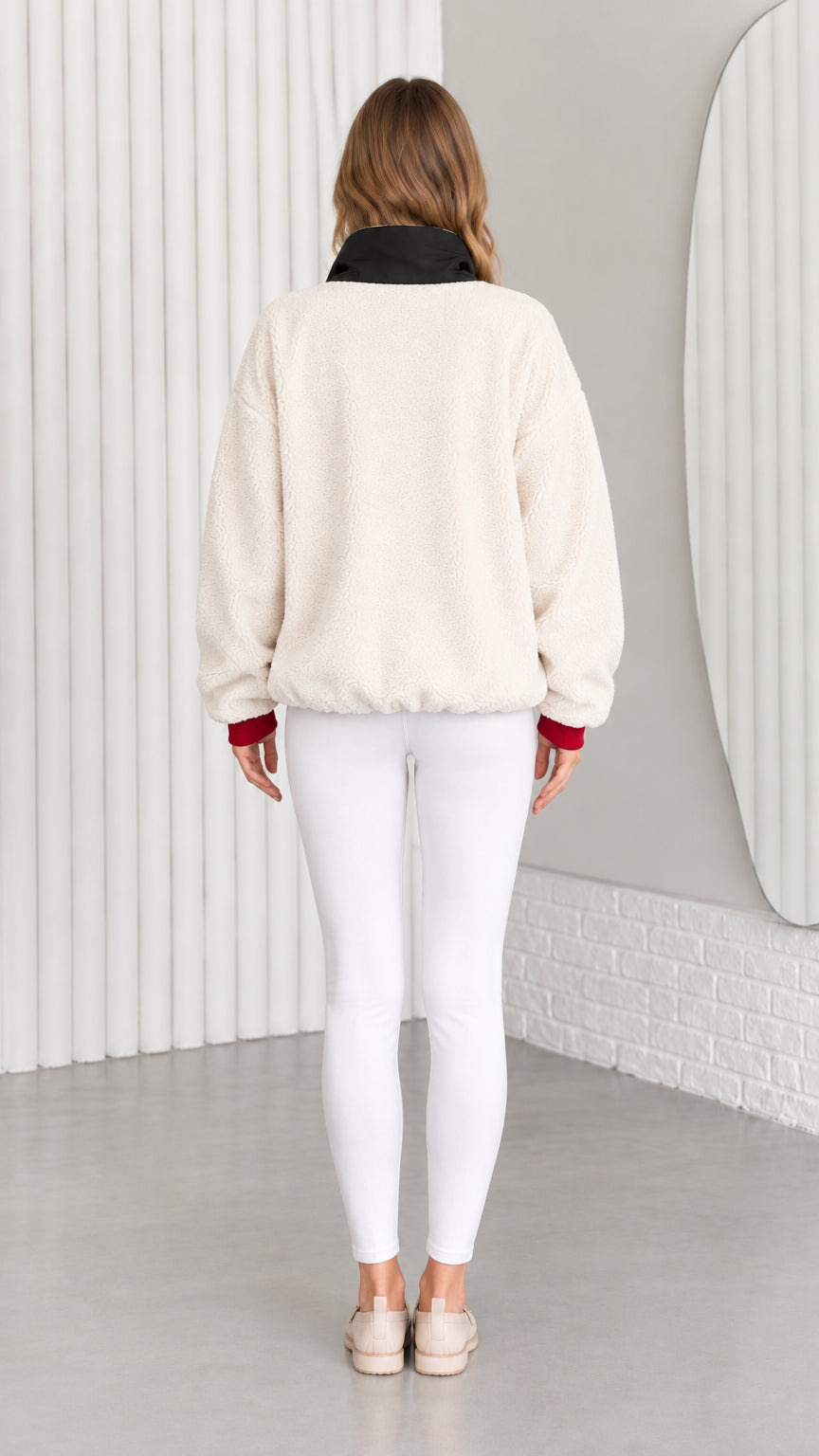 Back view of model wearing cream fleece pullover with contrast black collar
