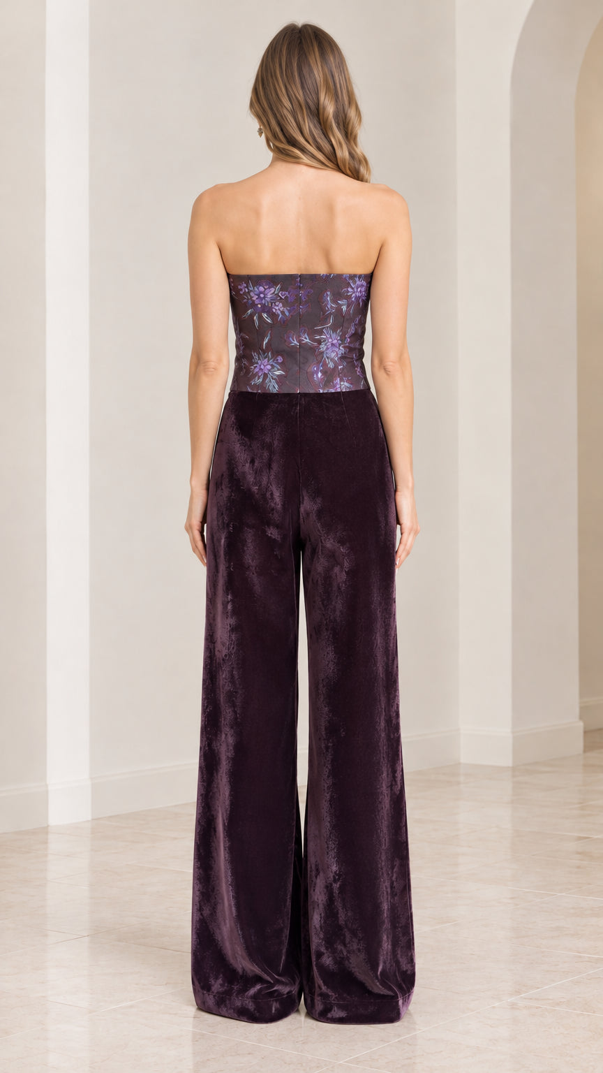 Back view of woman wearing strapless plum purple velvet jumpsuit