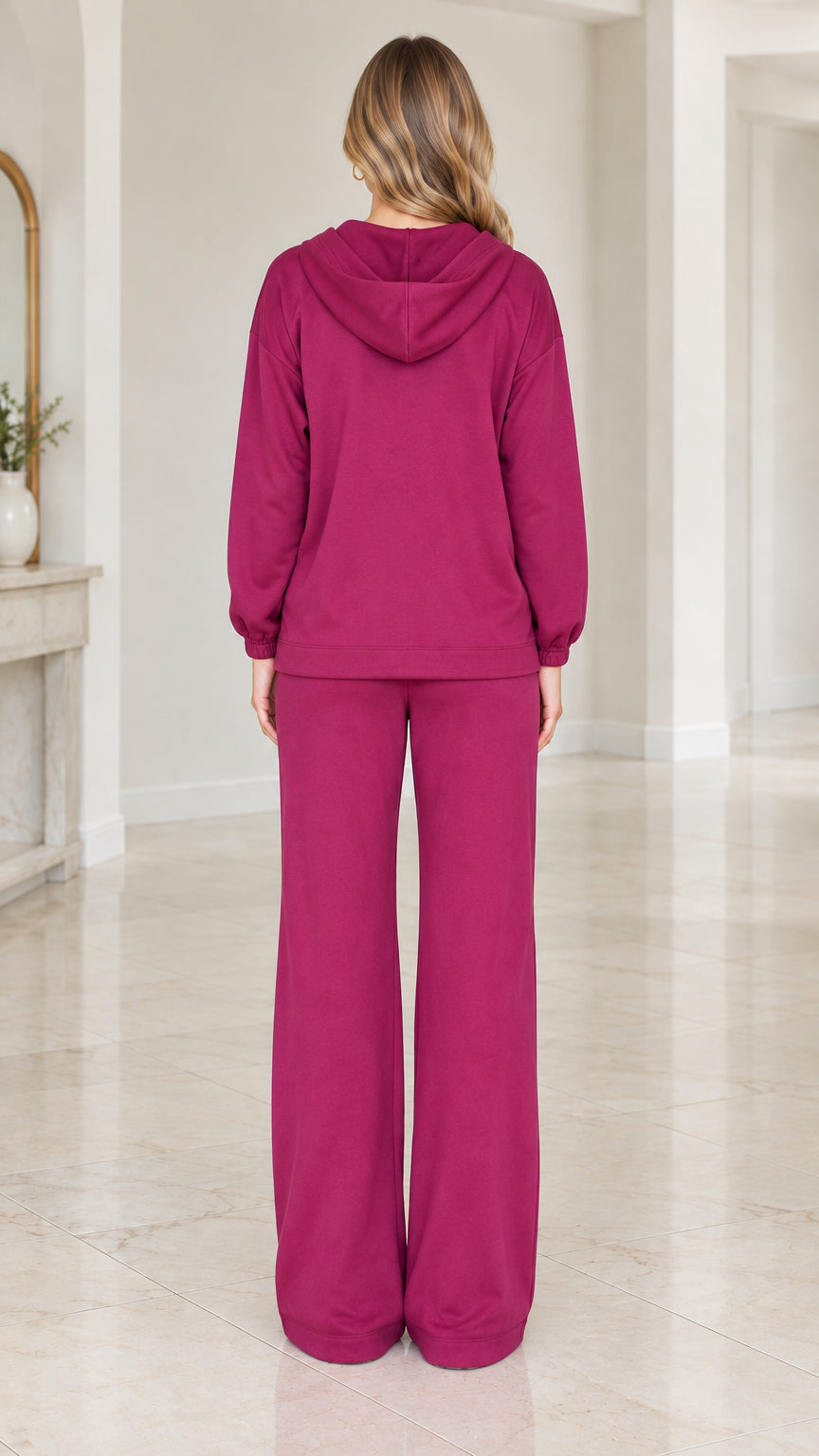 Back view of woman wearing berry purple hooded tracksuit with wide-leg pants