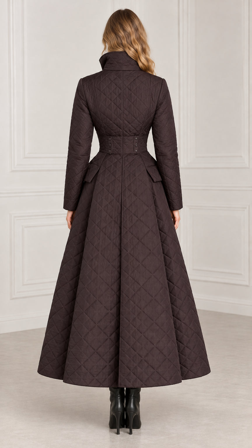 Back view of dark brown fit-and-flare quilted maxi coat showing waist tab detail