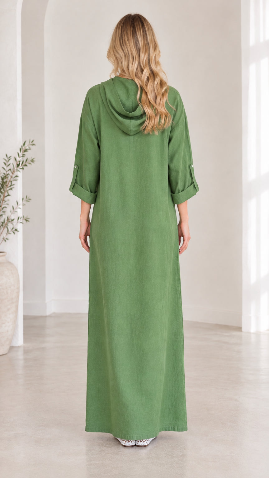 Back view of woman wearing green hooded maxi dress