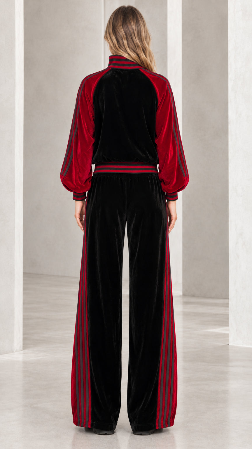 Back view of model wearing black and red plush velvet track jacket and wide-leg pants