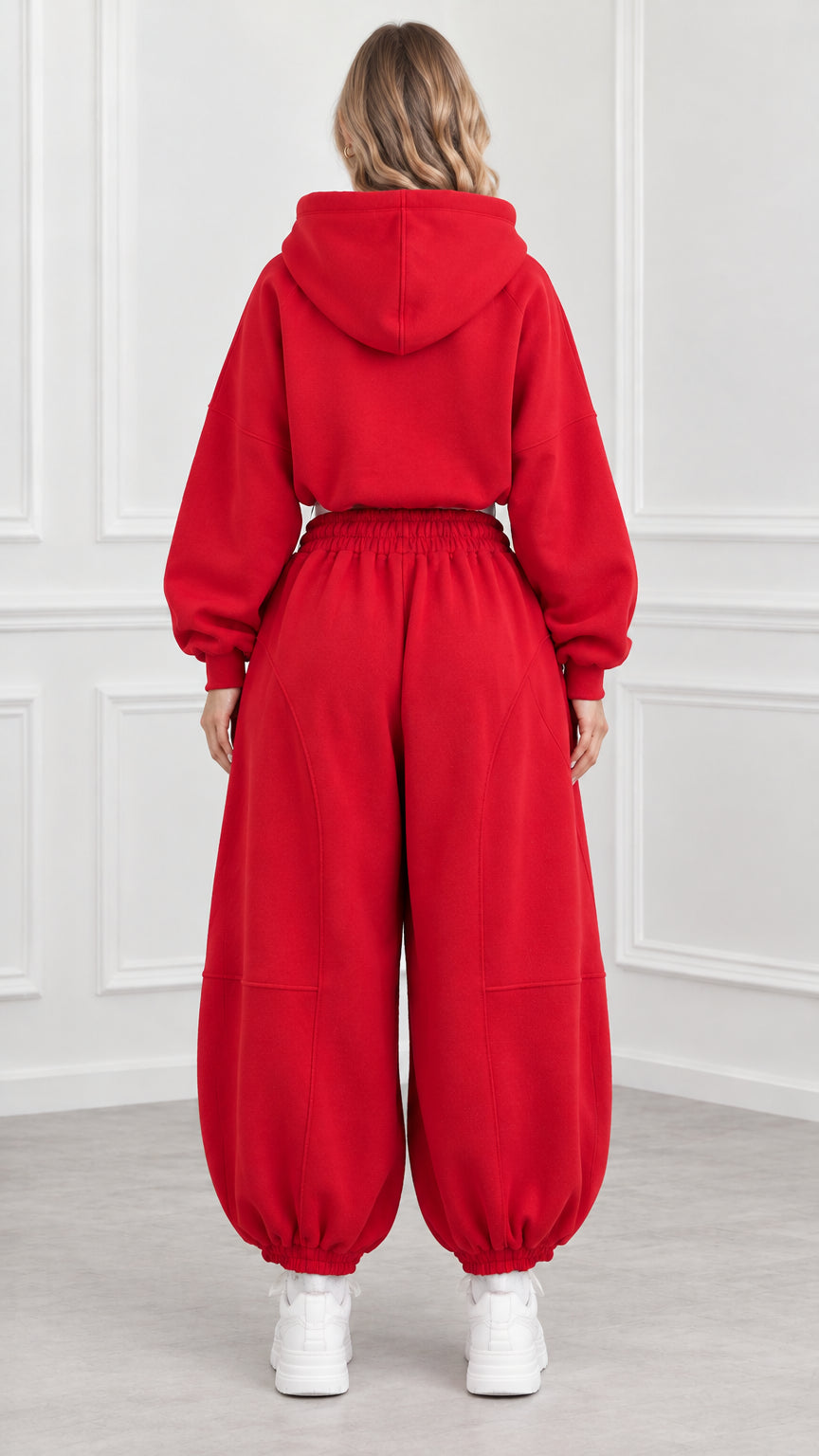 Back view of model wearing red hooded sweatshirt and relaxed joggers