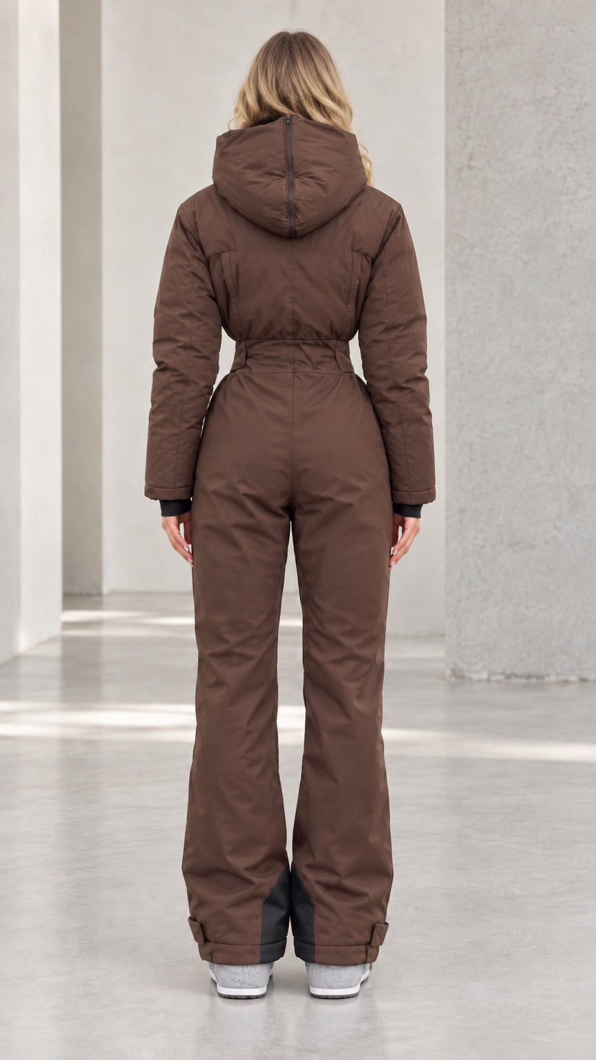 Back view of woman wearing chocolate brown hooded ski suit