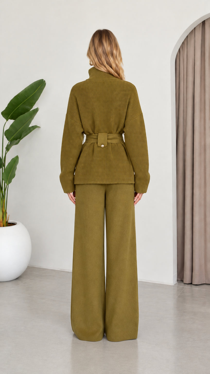 Back view of model wearing the Olive Green ribbed knit sweater and wide-leg pants
