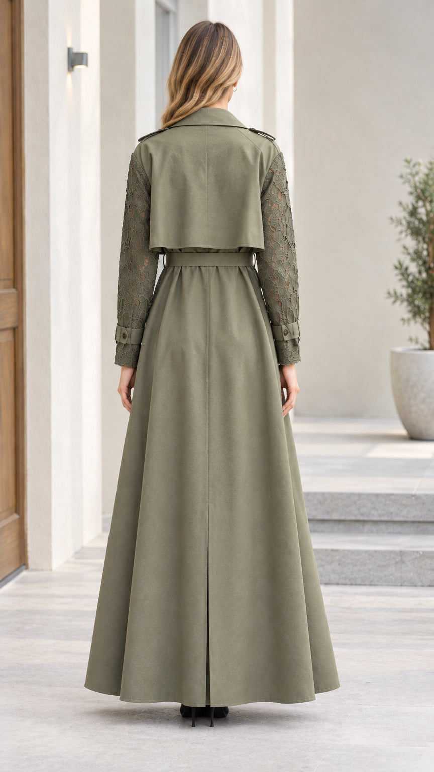 Back view of olive green maxi trench coat showing storm flap detail and flared skirt
