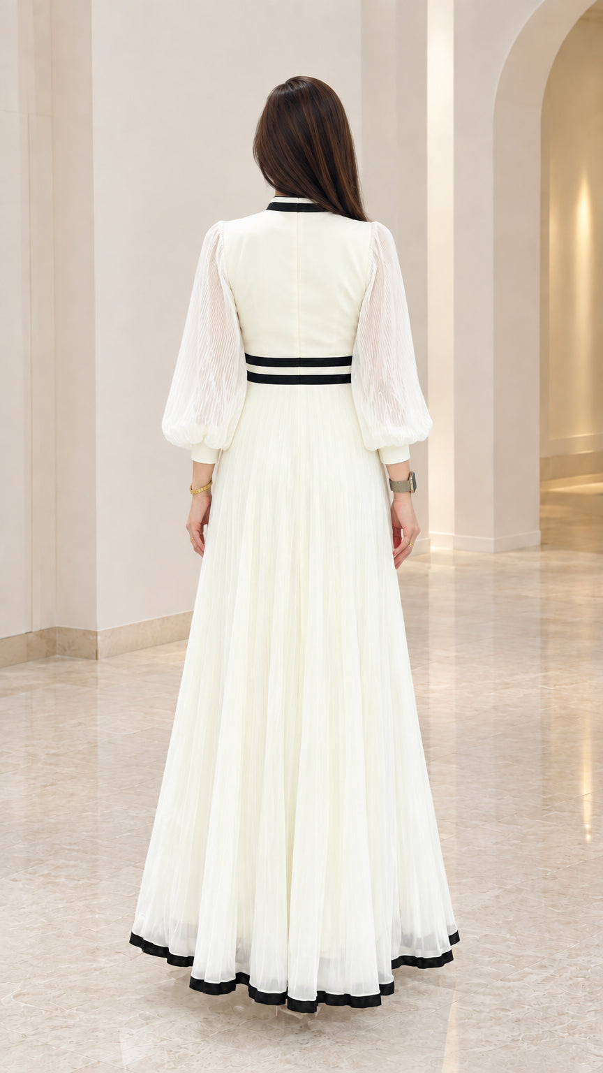Back view of white pleated floor-length dress showing fitted waist detail