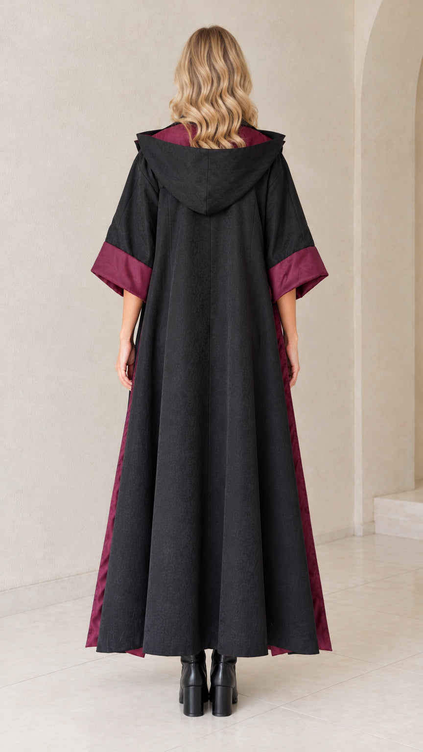 Back view of black hooded duster showing hood drape and ankle-length cut