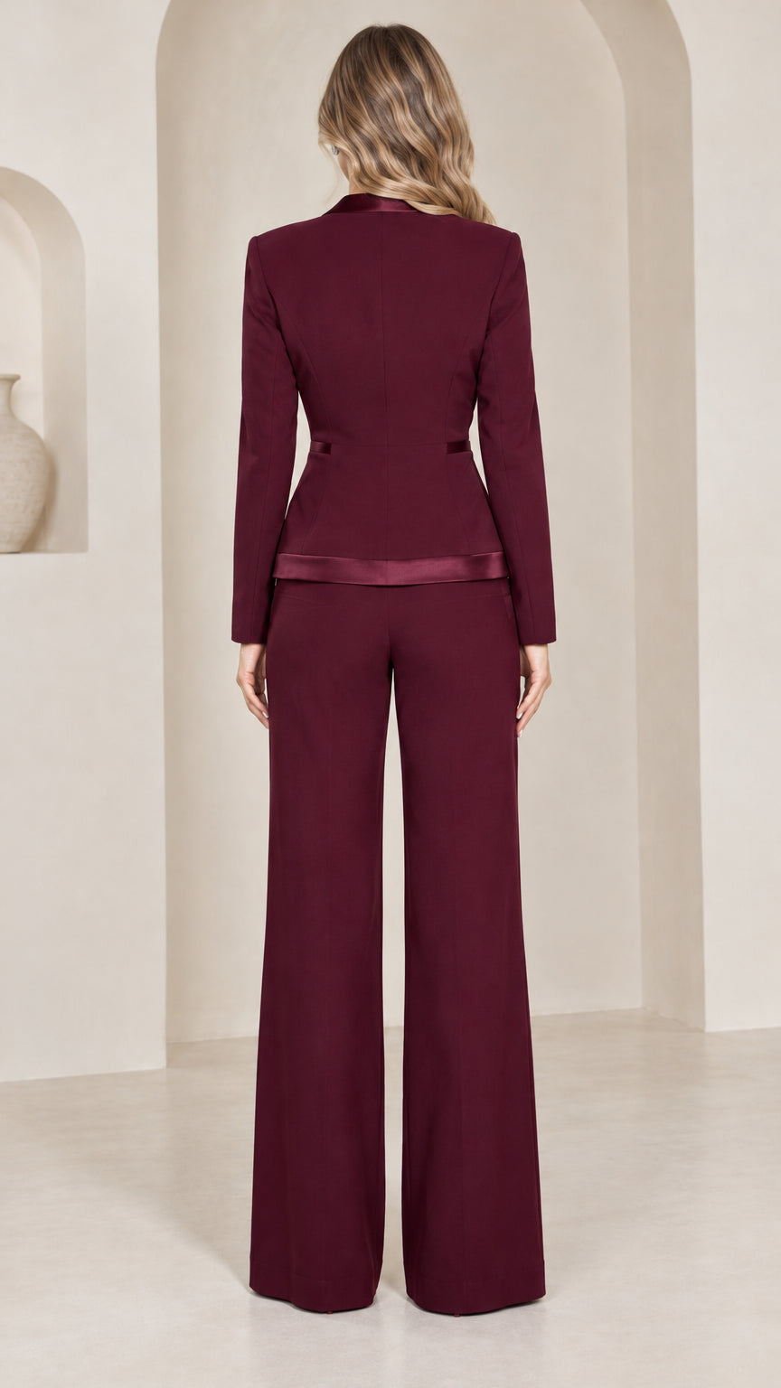 Back view of model wearing burgundy fitted blazer and wide-leg trousers