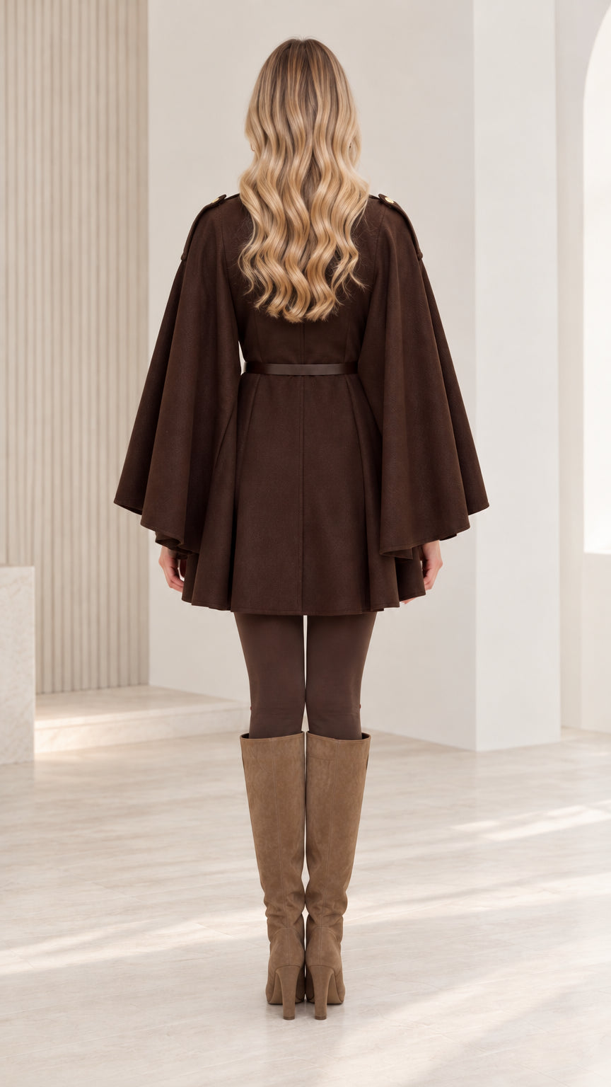 Back view of woman wearing chocolate brown belted cape coat with elegant draped design