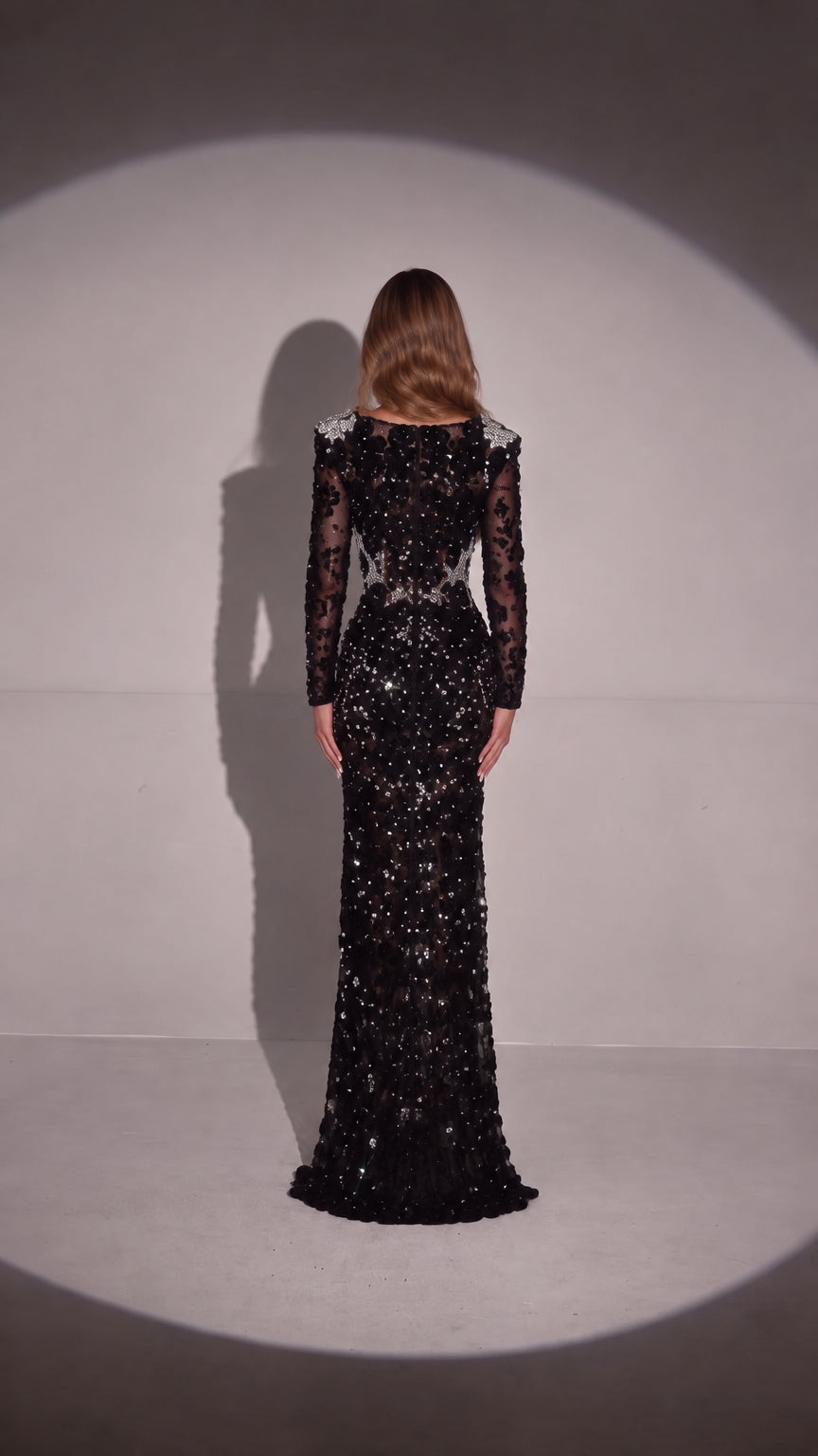 Back view of woman wearing Black long sleeve crystal embellished formal evening gown