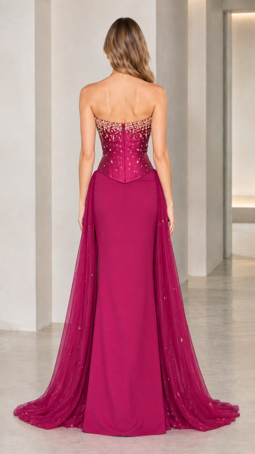 Back view of magenta strapless corset gown showcasing flowing tulle train