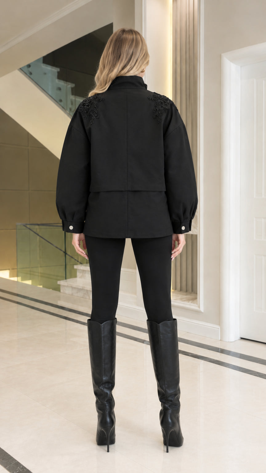 Back view of model wearing black utility jacket showing shoulder detailing