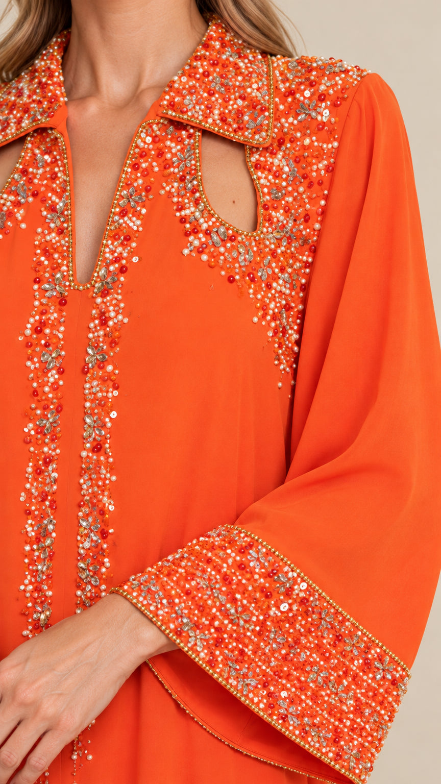 Close-up detail of beaded collar and shoulder cutouts on orange kaftan dress