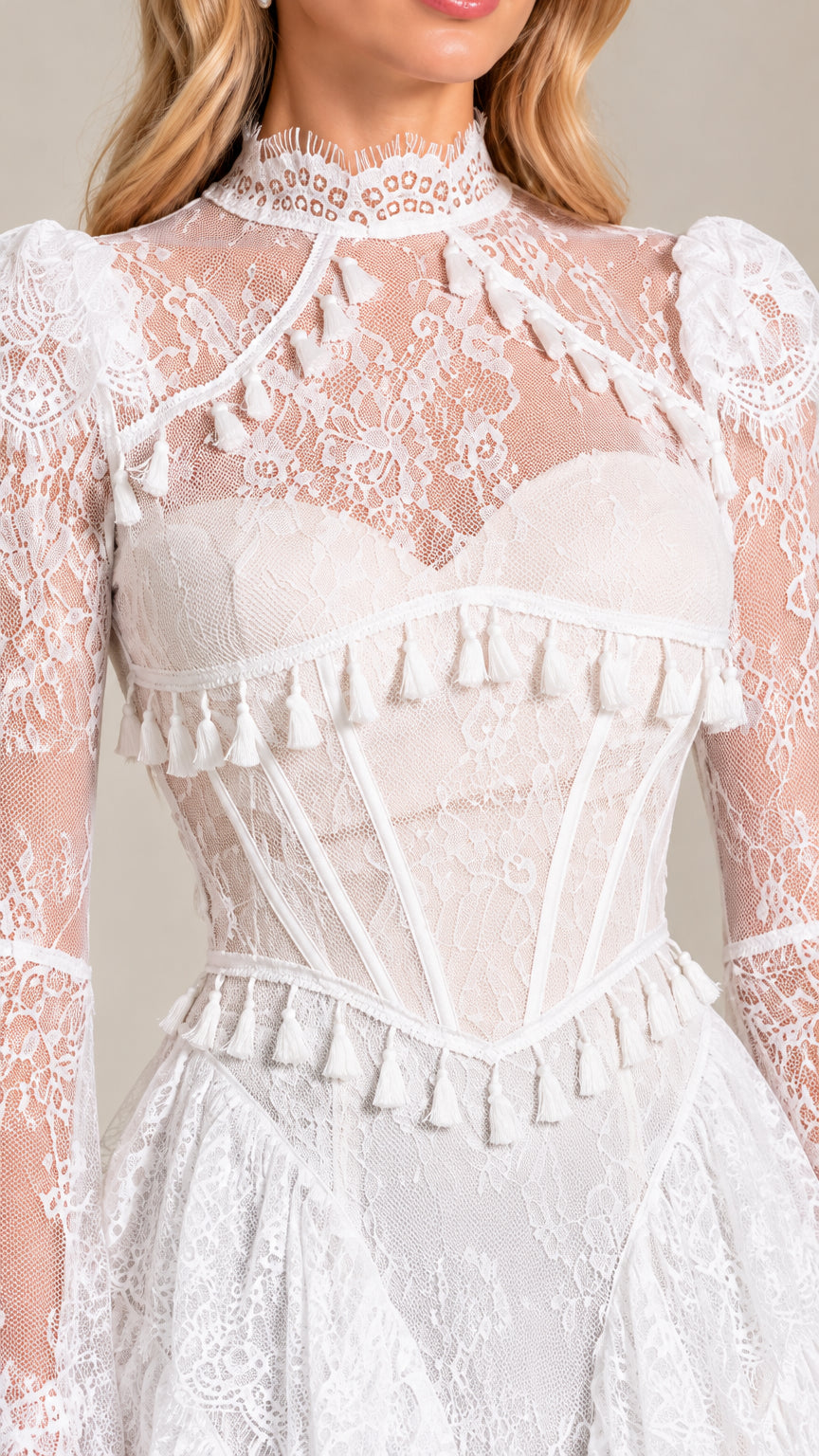 Close up detail of white lace bodice with corset boning, sweetheart lining, and tassel trim
