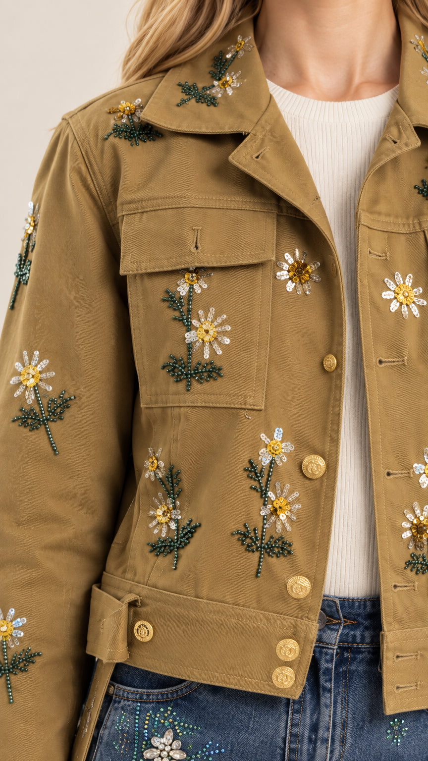 Close-up detail of floral embroidery, beading, and button hardware on jacket collar and chest pocket
