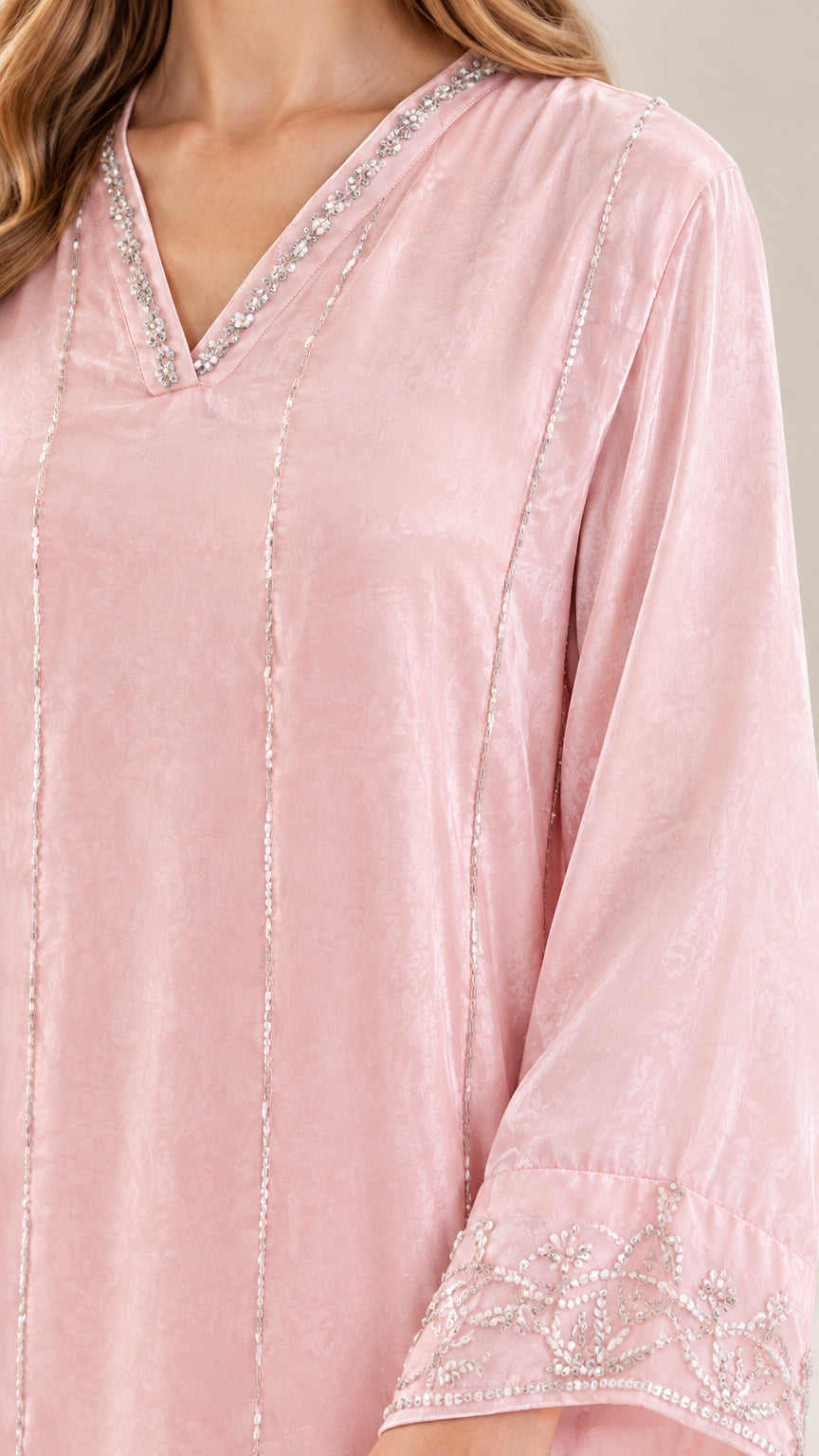 Close-up detail of beaded V-neckline and embellished cuff on Blush Pink dress
