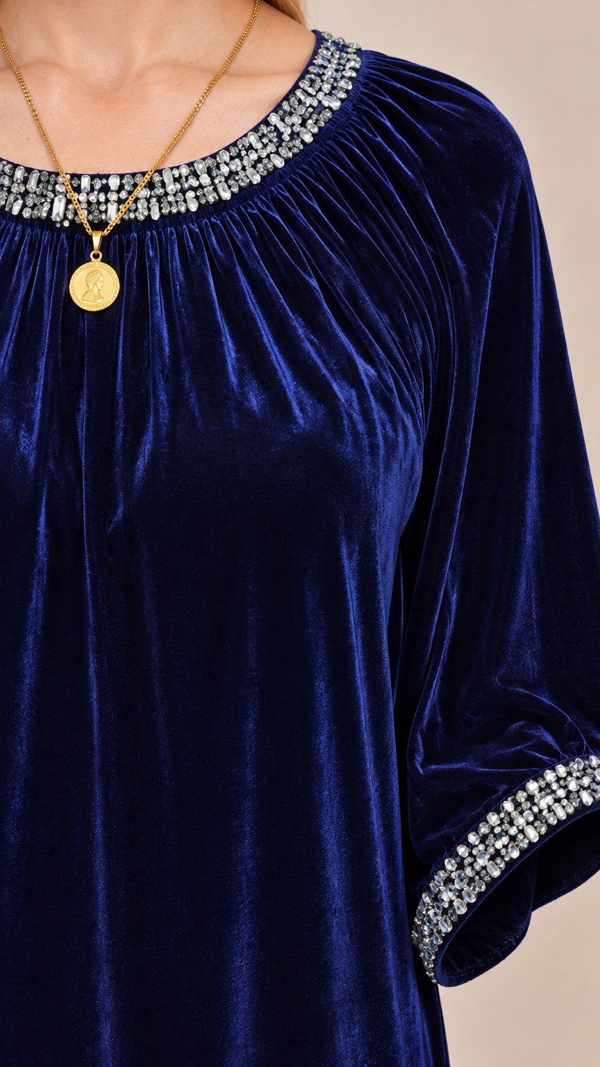 Close-up of gathered neckline with sparkling rhinestone trim on velvet dress