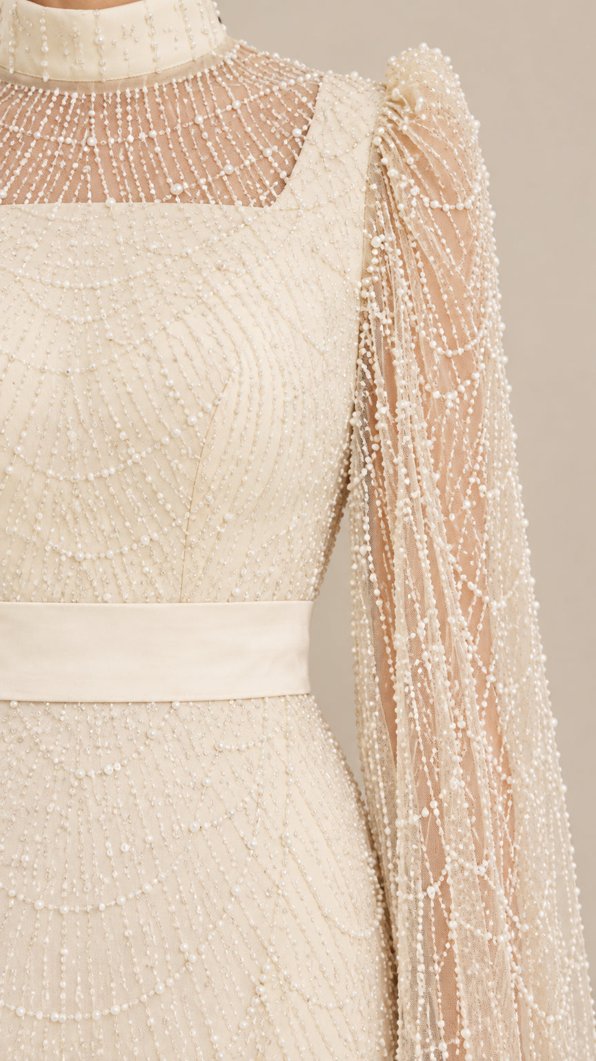 Close-up detail of high mock neckline and intricate beaded cape sleeve